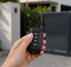 Télécommande dans une main avec portail en arriere plan